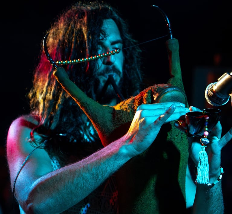 a man with long hair and a beard playing a Tunisian Mezoued