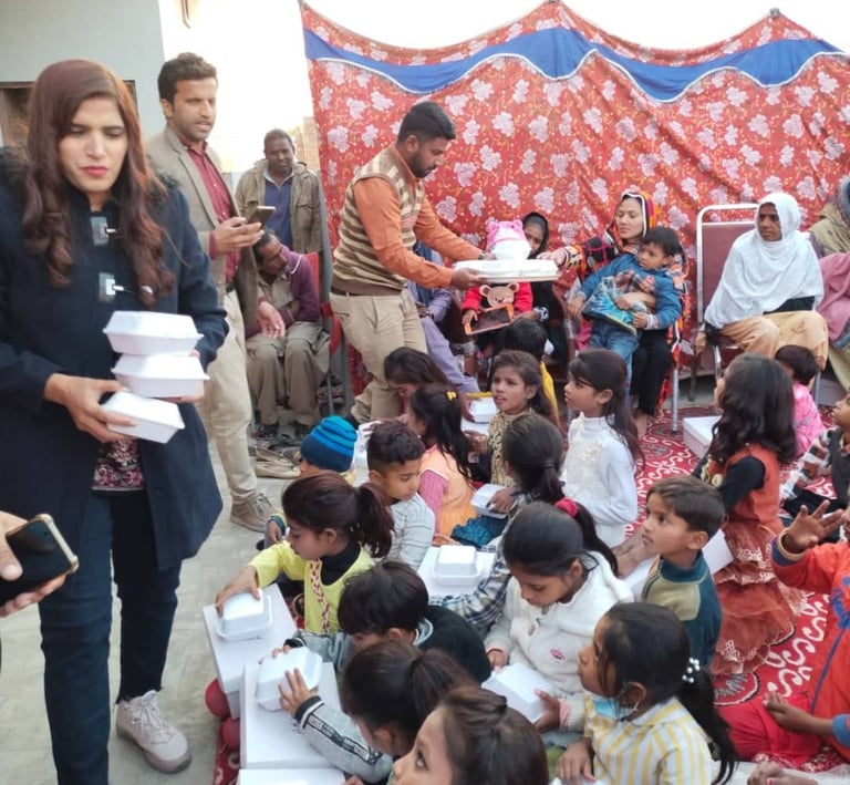 Volunteers distributing boxed meals to a group of children at a community charity event.