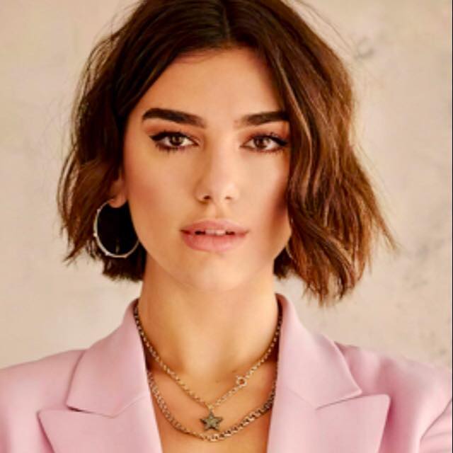 a woman with a pink jacket and a necklace