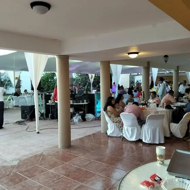 Invitados disfrutando servicio de carnitas para eventos en celebracion familiar en terraza