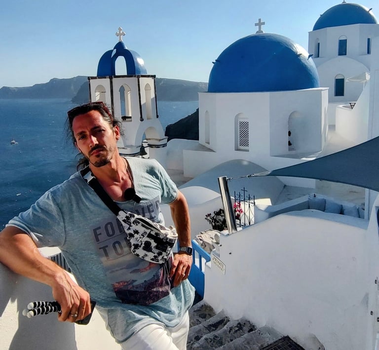 Turista en Santorini, Grecia, con vistas a las icónicas cúpulas azules y edificios blancos sobre el 