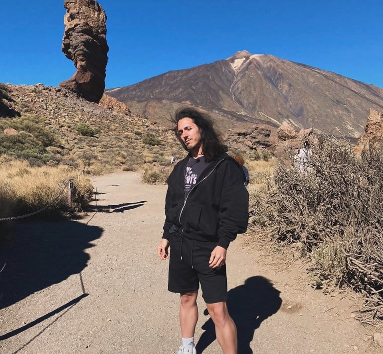 Senderista posando en el Parque Nacional del Teide, Tenerife, con el volcán Teide y el Roque Cinchad