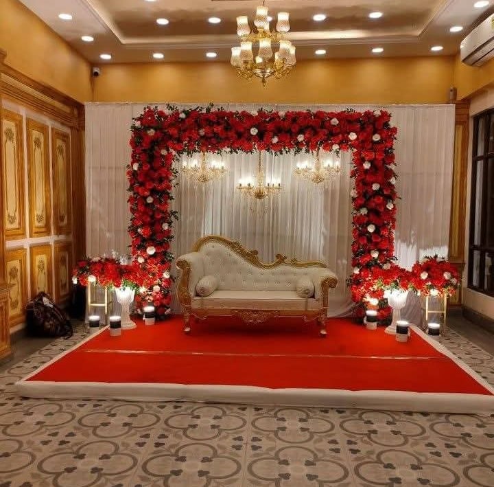 a wedding ceremony with a red carpet and a white couch