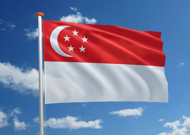 Magnificent Singapore national flag waving in the blue sky with red and white colors, crescent moon and five stars visible