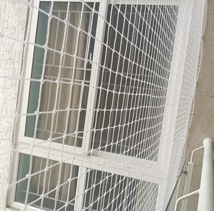 Wide view showing a Prestige apartment balcony fully covered with a neatly fitted pigeon net.