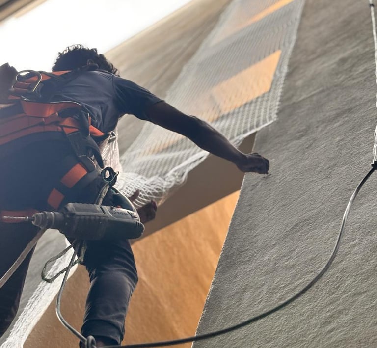 Technician from Arjilli Safety Nets fitting duct nets on a residential building in pune