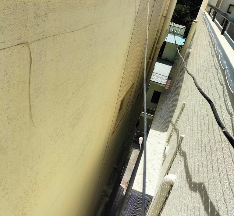 Side view of the net installation process, highlighting the careful attachment to balcony railings.