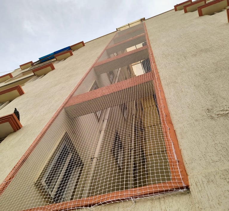 Apartment balcony duct area secured with pigeon net for hygiene and safety.