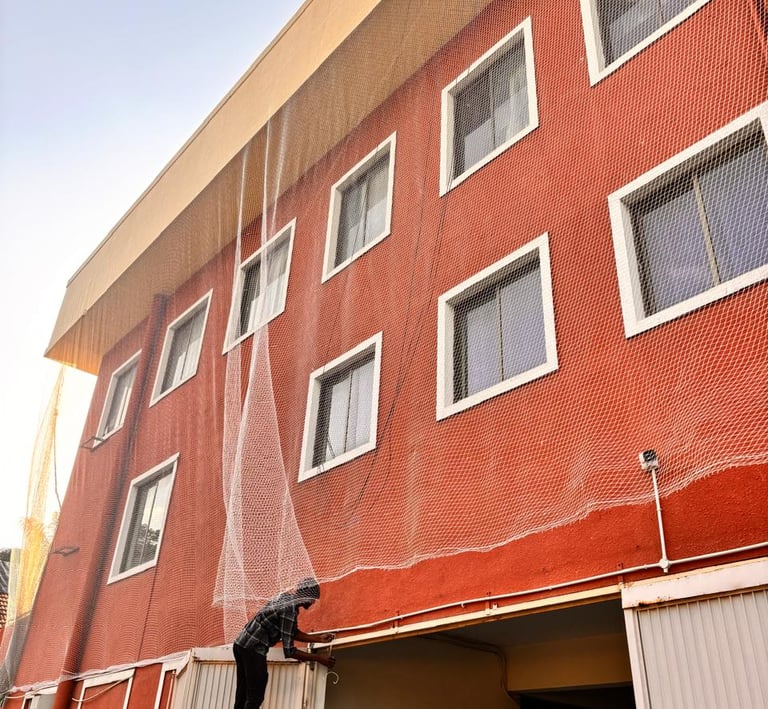 Duct area pigeon net fitted in high-rise apartment to prevent pigeons and droppings.