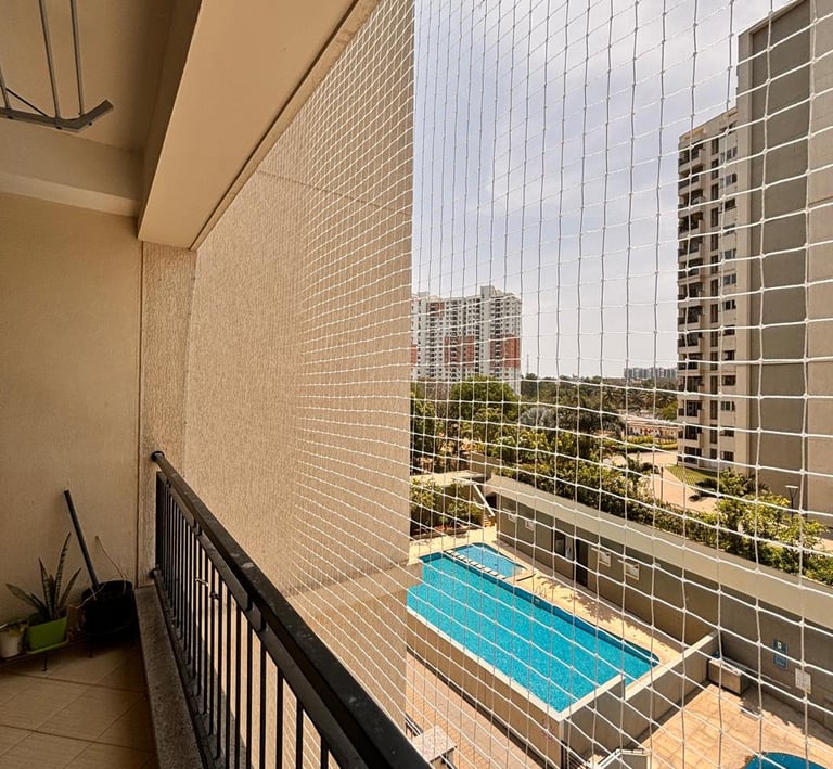 Technician carefully fitting a safety net frame on a residential balcony in Malabar Hill.