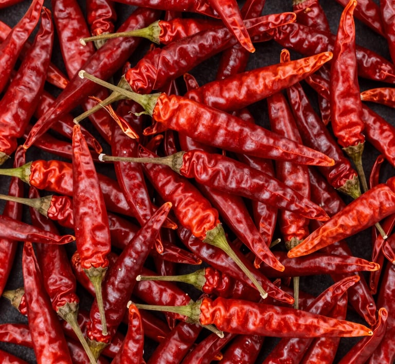 Fresh green peppercorn clusters hanging on the vine in a sunlit spice farm.
