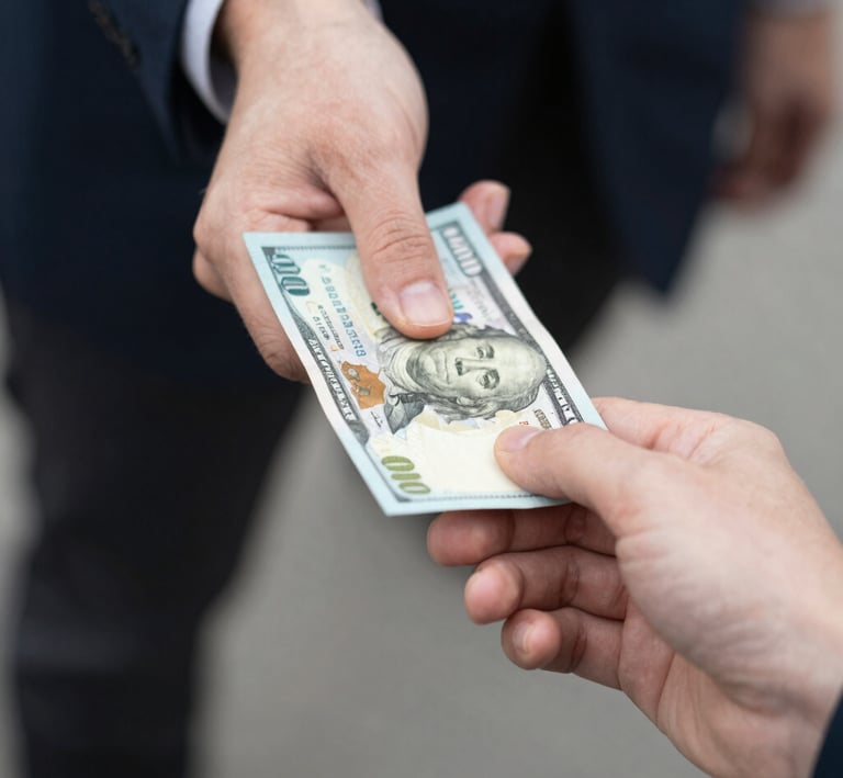 A close-up of hands exchanging money with a warm background of a restaurant.