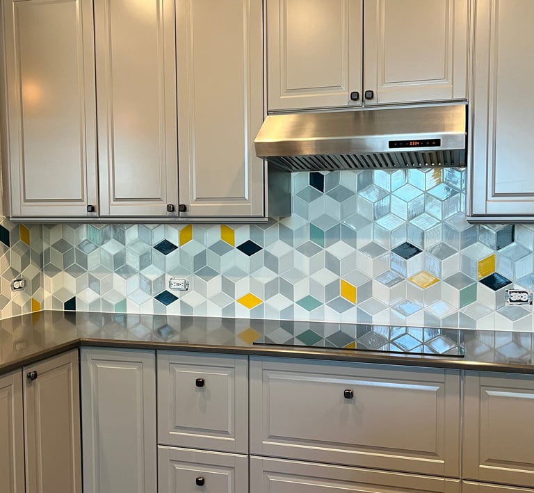 Modern kitchen featuring grey cabinets, a stainless steel range hood, and a geometric 3D cube tile backsplash.
