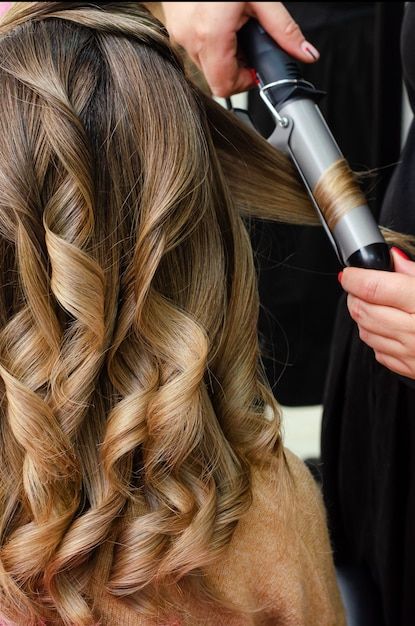 a woman is blow drying her hair in a salon Abu Dhabi