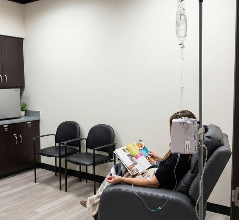 Patient receiving IV infusion therapy while seated in a comfortable recliner in a neurology clinic.