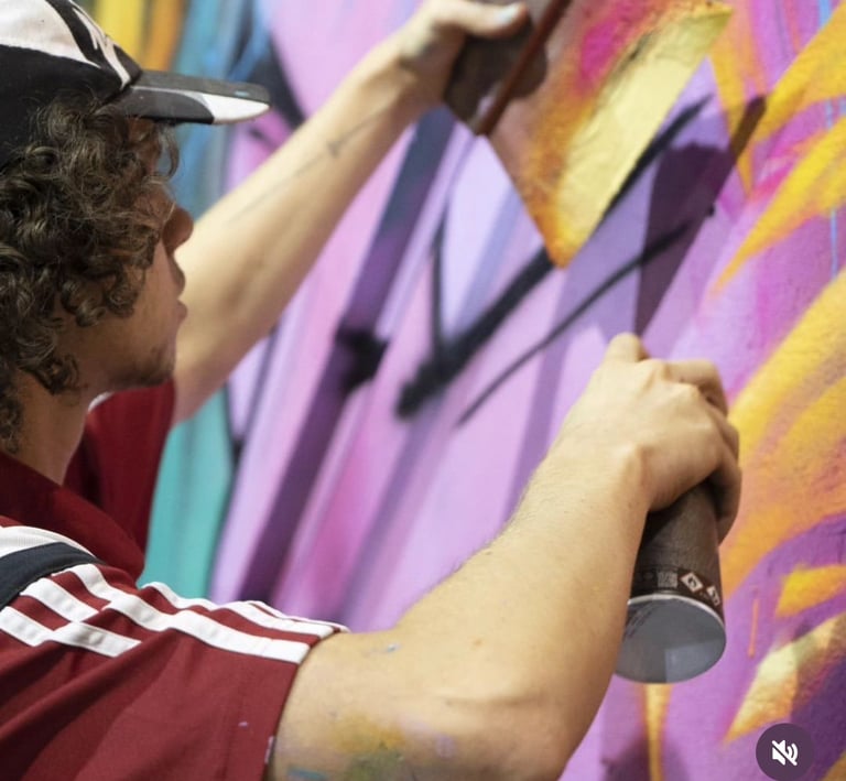 un homme avec une casquette entrain de peindre un graff