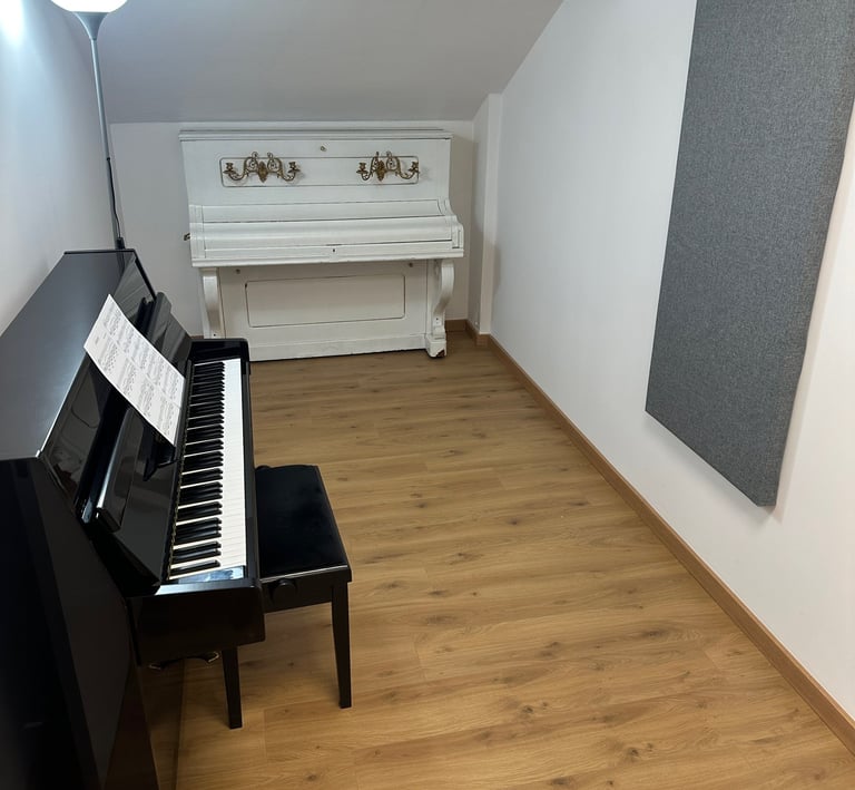 a yamaha b1 piano in a little room with a white piano