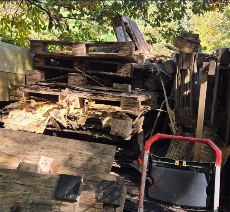 Pld pallets, junk wood, trash and more on a residential property.