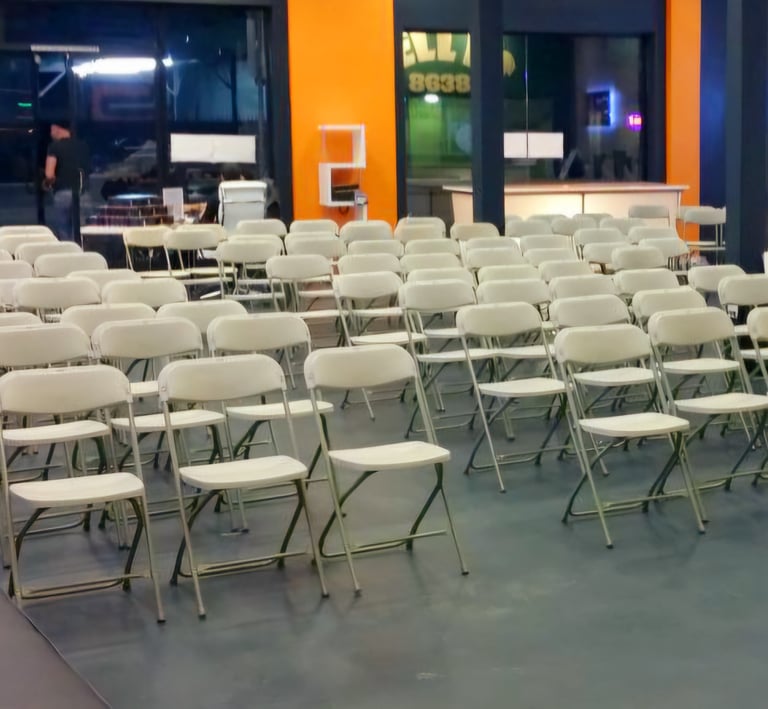 Sillas blancas plegables para eventos corporativos en el paso