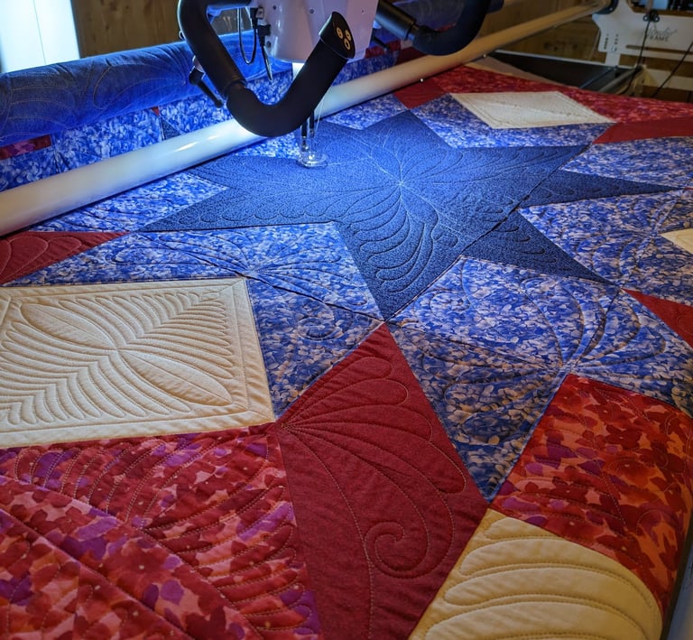 a patriotic quilt being stitched on a longarm machine