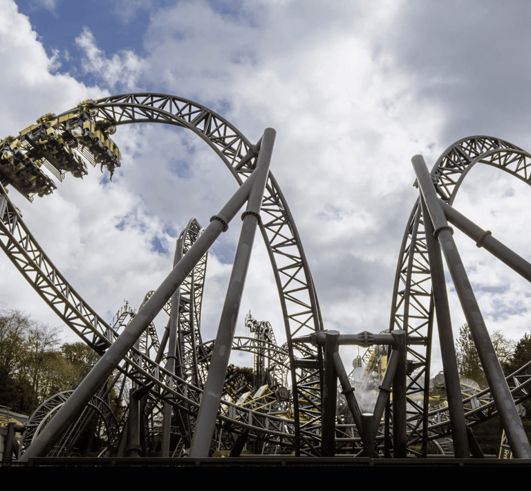 A Roller coaster in the shape of eyes and a smile with a cart on a loop to the left  