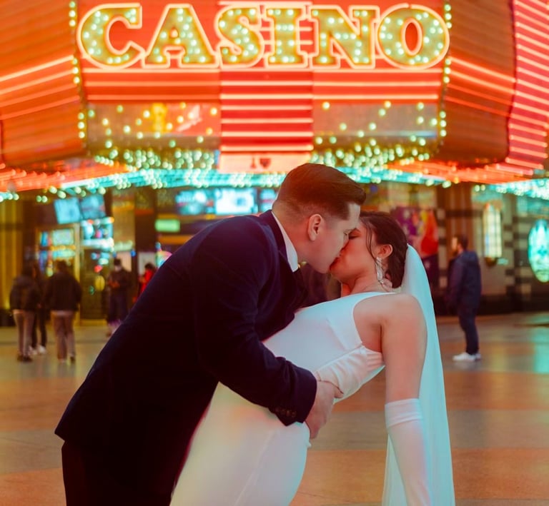 a bride and groom kissing in front of a casino