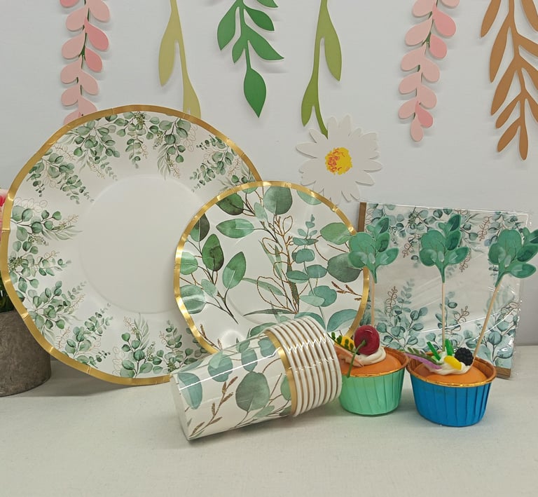 Floral eucalyptus paper plates and party supplies set with matching cups and napkins for a nature-themed event.