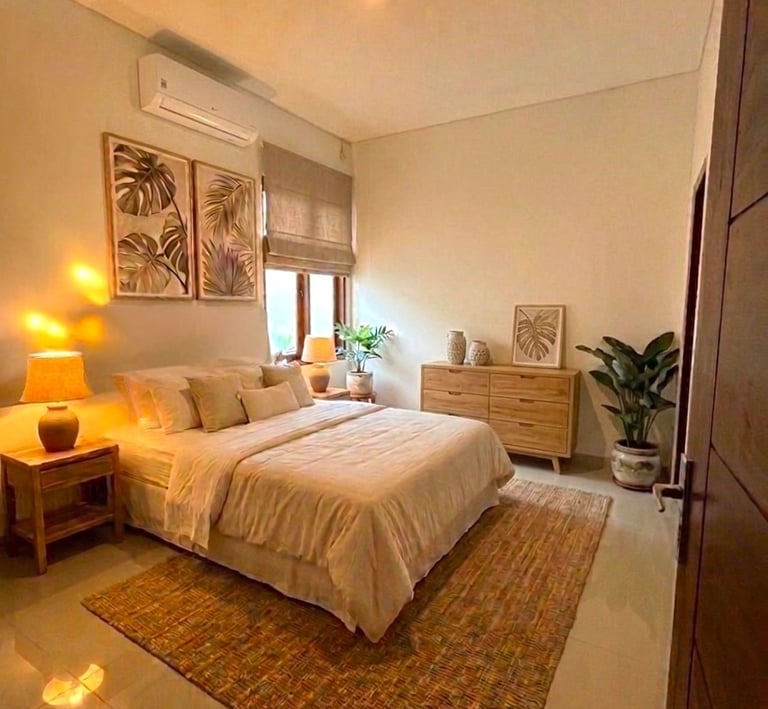 Modern tropical bedroom interior with warm lighting, wood furniture, and botanical leaf wall art.