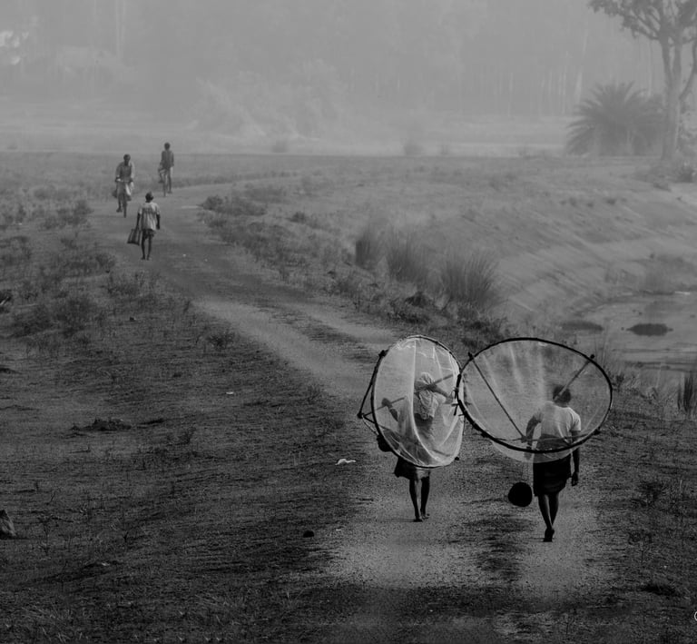 A black and white picture of some fisher women forwarding towards theri work with nets on back.