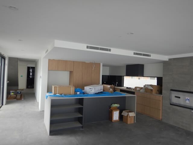 Registered builder conducting detailed building inspection in Perth home, assessing roof structure and wall alignment.