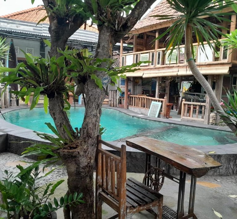 бассейн с деревянным столом и стульями вид в sunrise lodge lovina bali