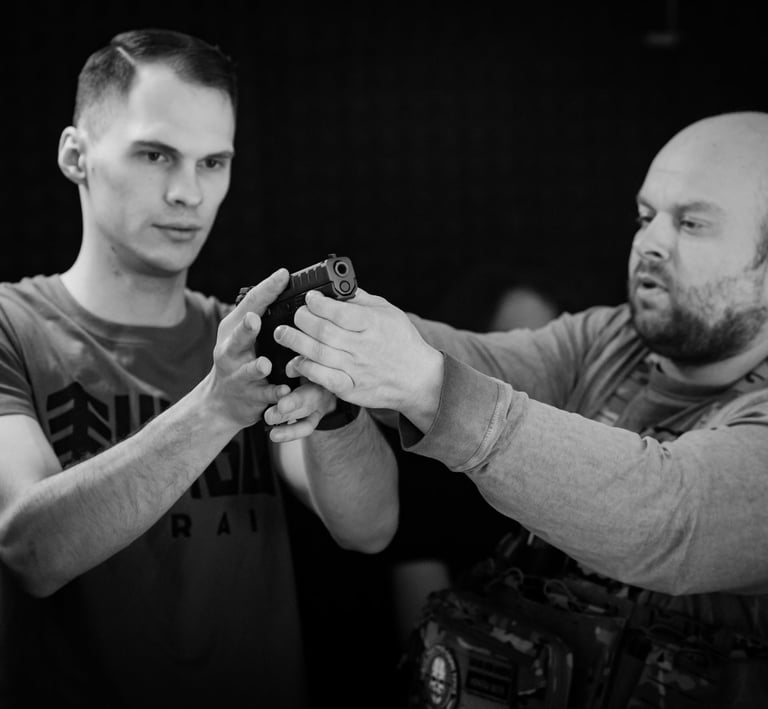 vyras su ginklu rankose ir instruktorius šalia