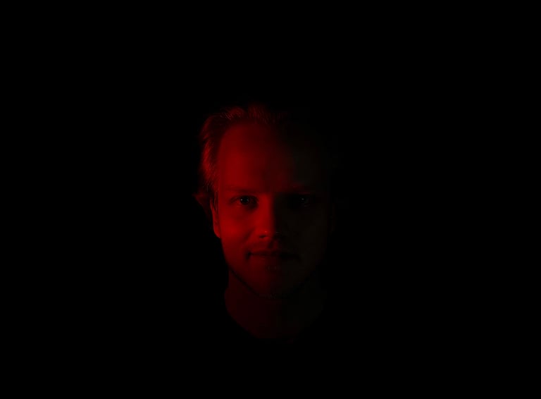 a dark picture of a man with a red reflection
