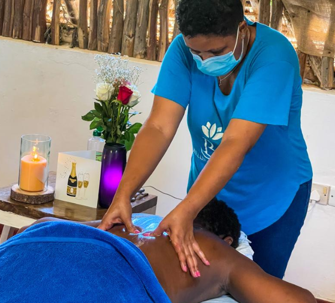 a woman in a blue shirt is getting a massage