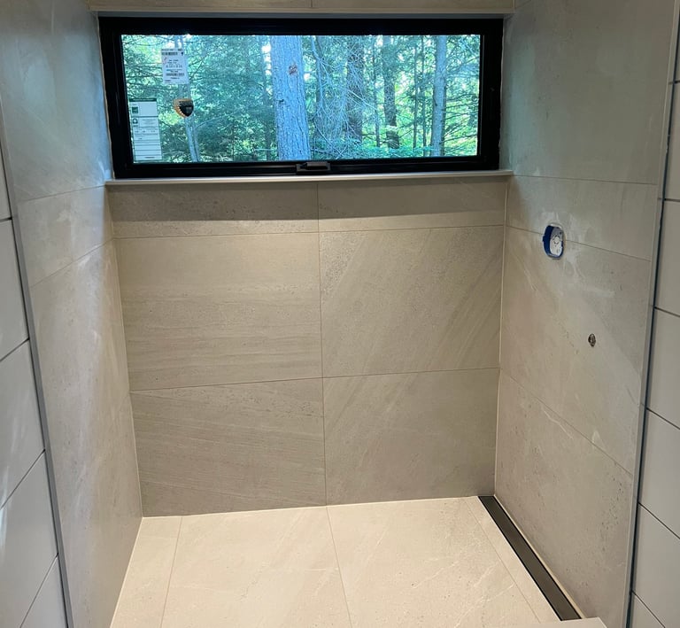 Modern walk-in shower featuring large format beige porcelain tiles.