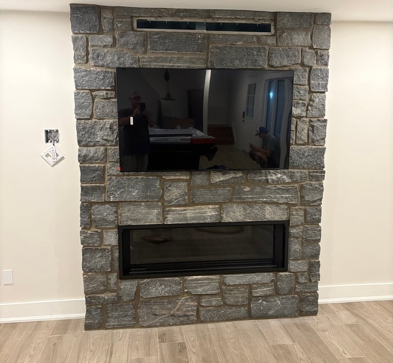 Muskoka granite fireplace wall with mounted TV and linear gas insert.