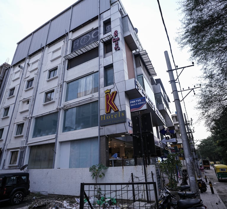Exterior view of the K Hotels building with signage and street view in an urban city setting.