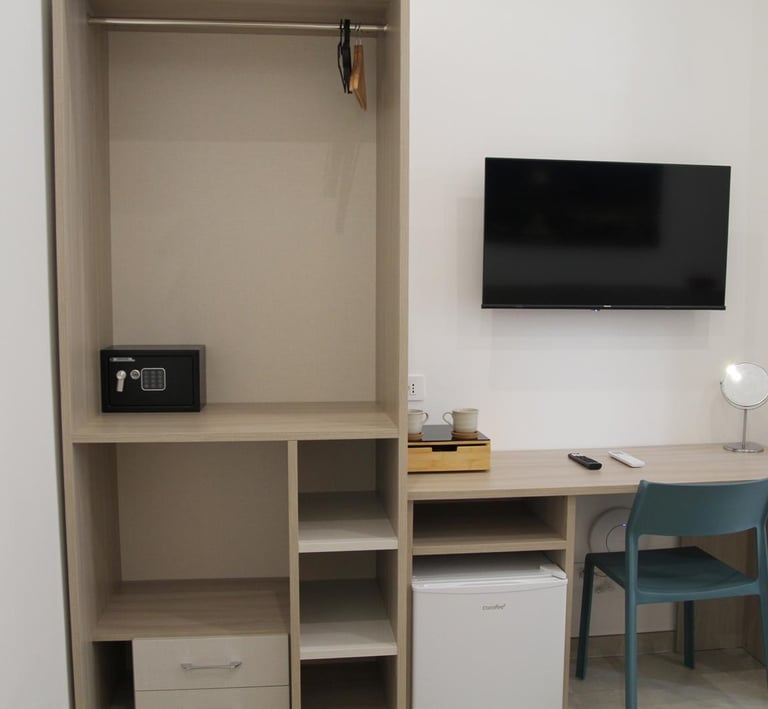 armadio, cassaforte e scrivania con smart Tv