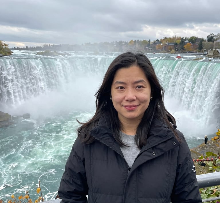 Close-up of one woman laughing with mist from Niagara Falls softly blurring the background.