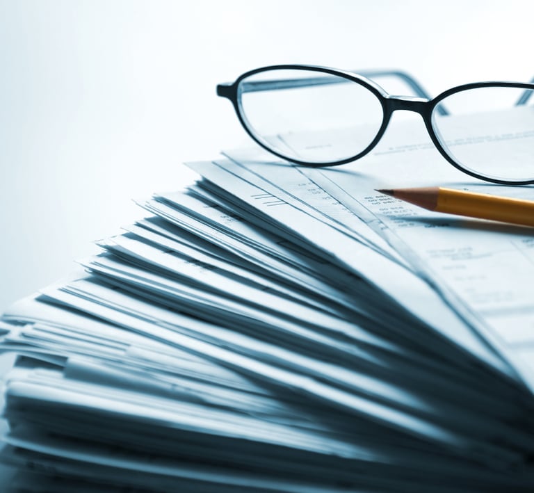 Stack of probate paperwork with reading glasses