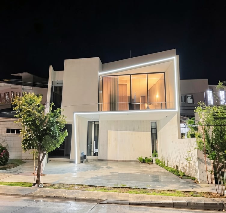 Fachada minimalista con iluminación arquitectónica y líneas de luz continuas.