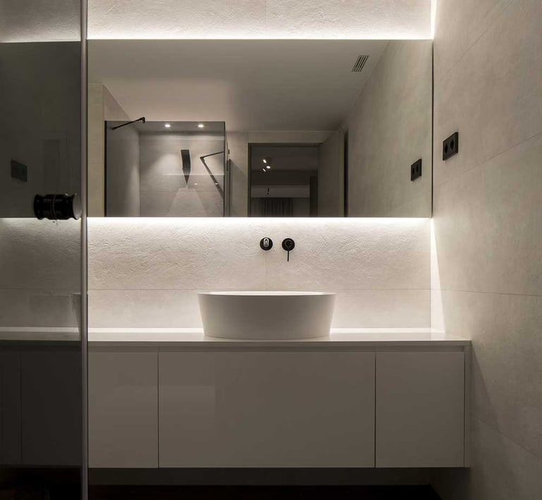 Detalle de espejo con perfiles LED superiores e inferiores para luz uniforme.