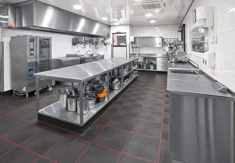 Large professional kitchen featuring workstations and an overshelf for benches.