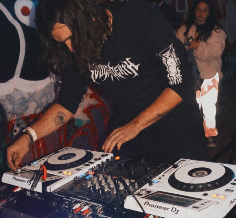 a man in a black shirt is playing a dj -Creechur