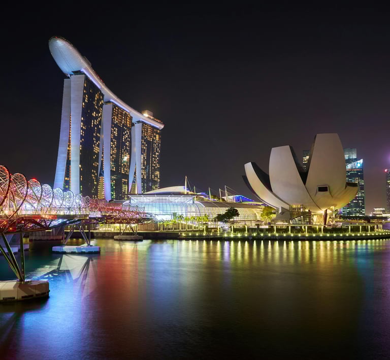Singapore Marina Bay Sands and Helix Bridge illuminated at night with city skyline reflections