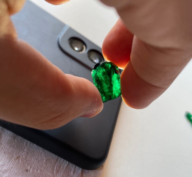 a person holding a green emerald in their hand