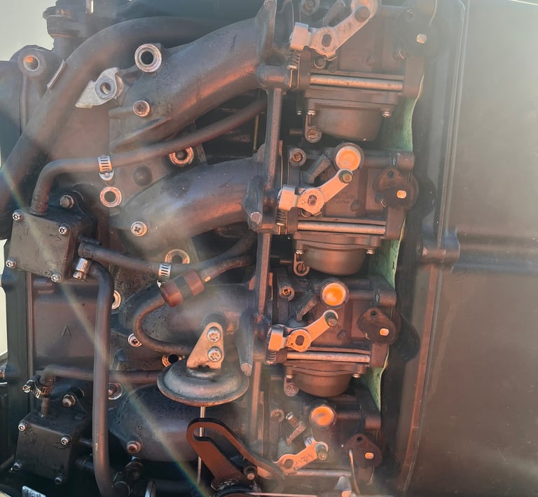 Close-up of a multi-carburetor boat engine assembly showing complex mechanical linkages and intake manifolds.