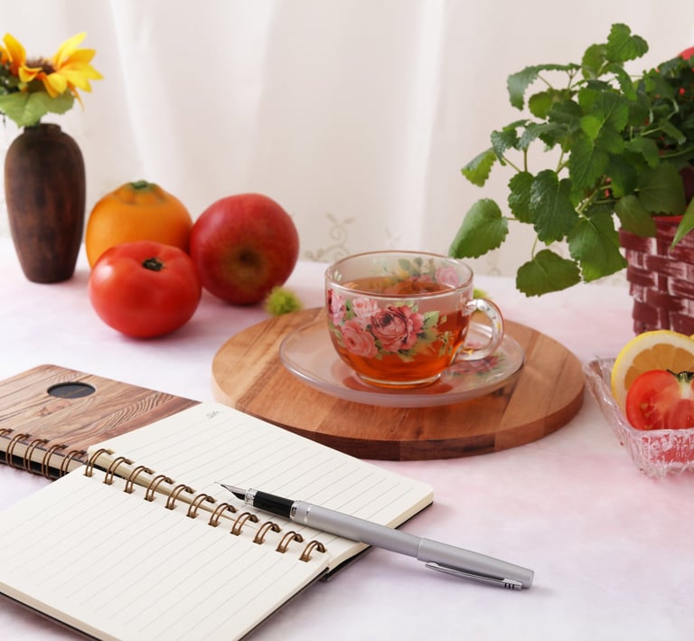 a notebook with a pen and a notebook with a pen and a cup of tea