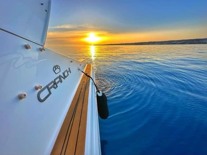 Side view of yacht cruising at sunset on Sicilian coast