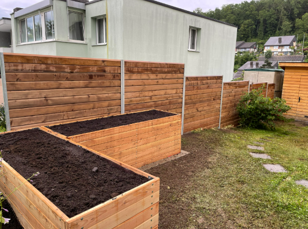 Hochbeete aus Holz im gepflegten Gartenbereich – nachhaltiger Gartenbau in Bülach mit individueller 